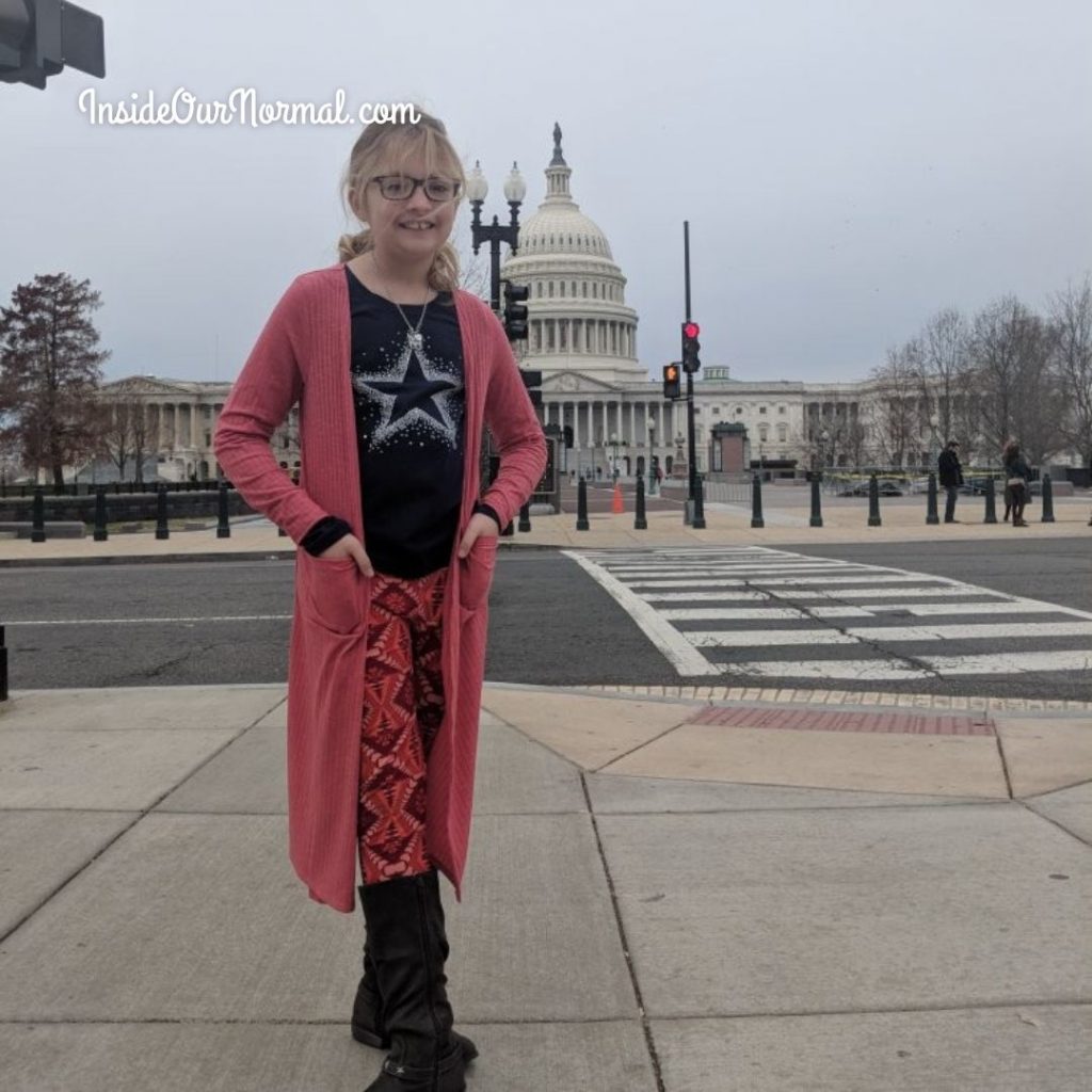 washington DC street with capitol building behind girl