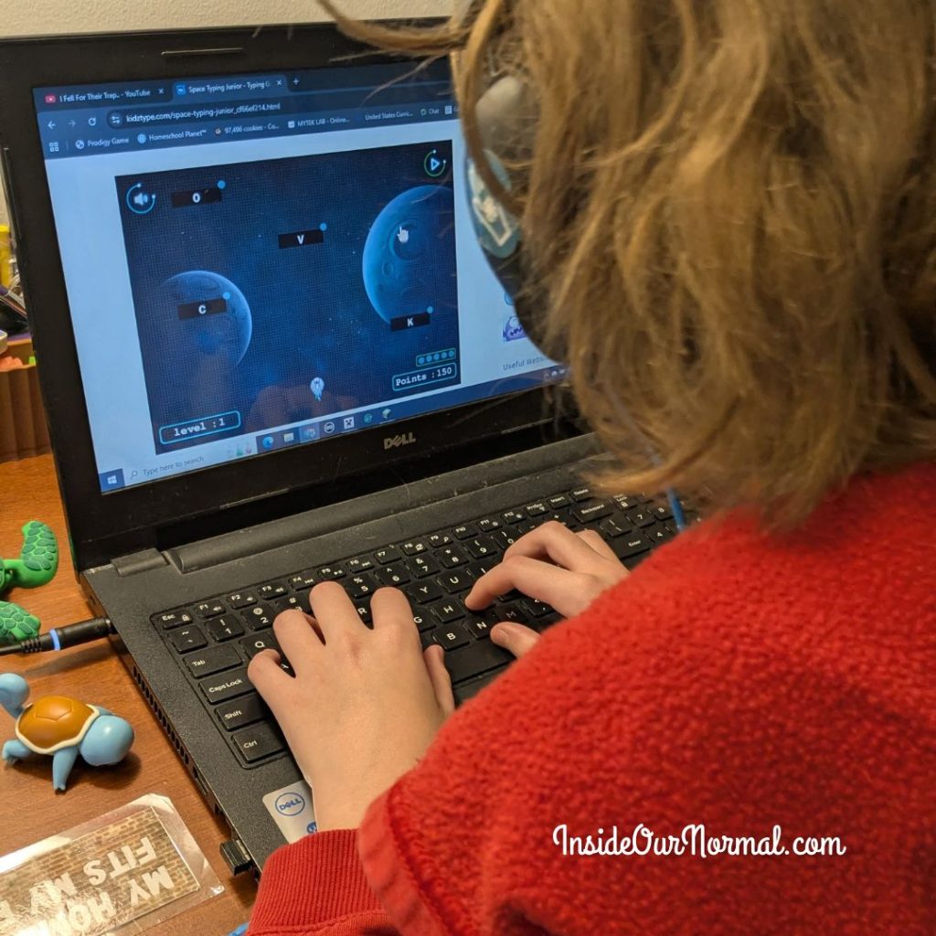 Autistic homeschool student smiling while playing a free typing game on KidzType — building focus, confidence, and digital learning skills.
